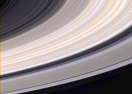 Cận cảnh các vành đai của Sao Thổ. Chúng có màu xám và rám nắng, và có những khoảng trống ở giữa để bạn có thể nhìn thấy màu đen của không gian qua chúng.
